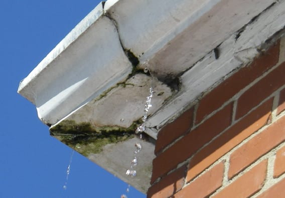 Leaking, stained eavestrough corner on a brick home before repair